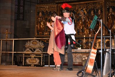 Martin legt der Bettlerin den Mantelteil um. 